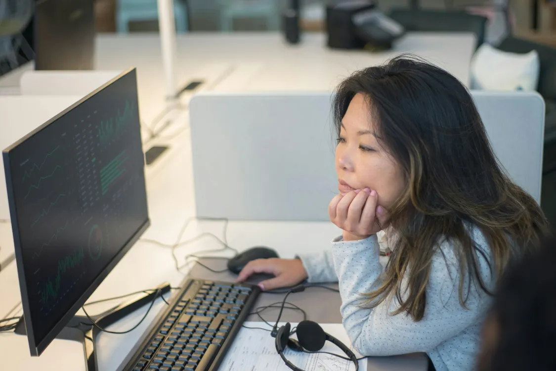 Filipino BPO worker analyzing data on a desktop computer in an office environment