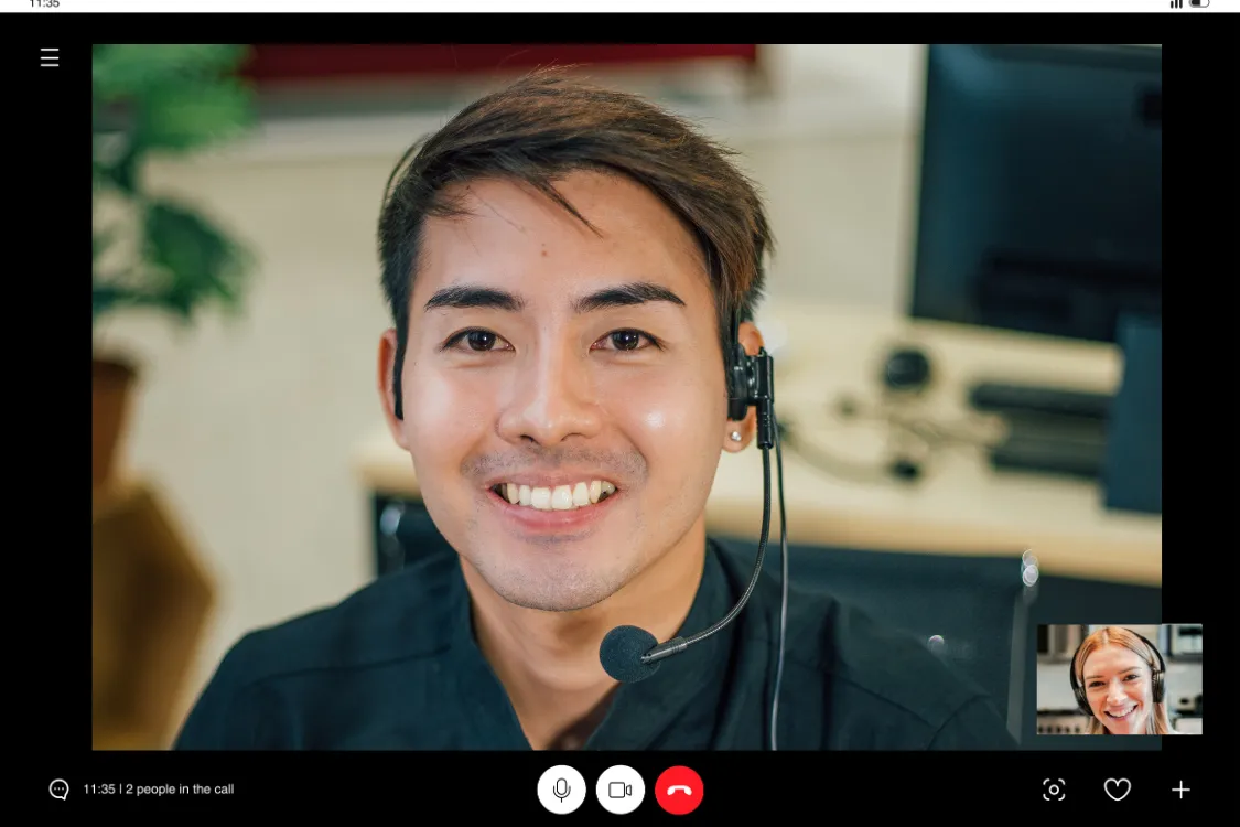 Filipino man with headset smiling during a virtual support or team meeting