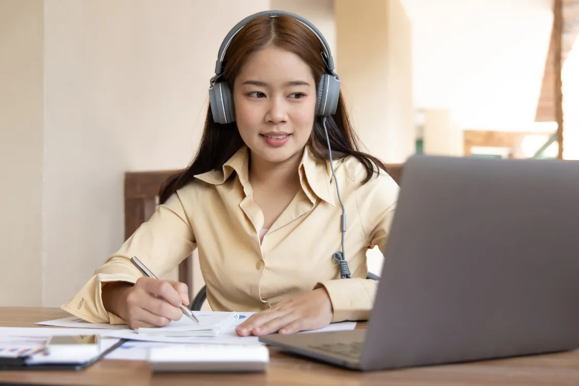 Filipino virtual assistant wearing headphones while taking an online test project