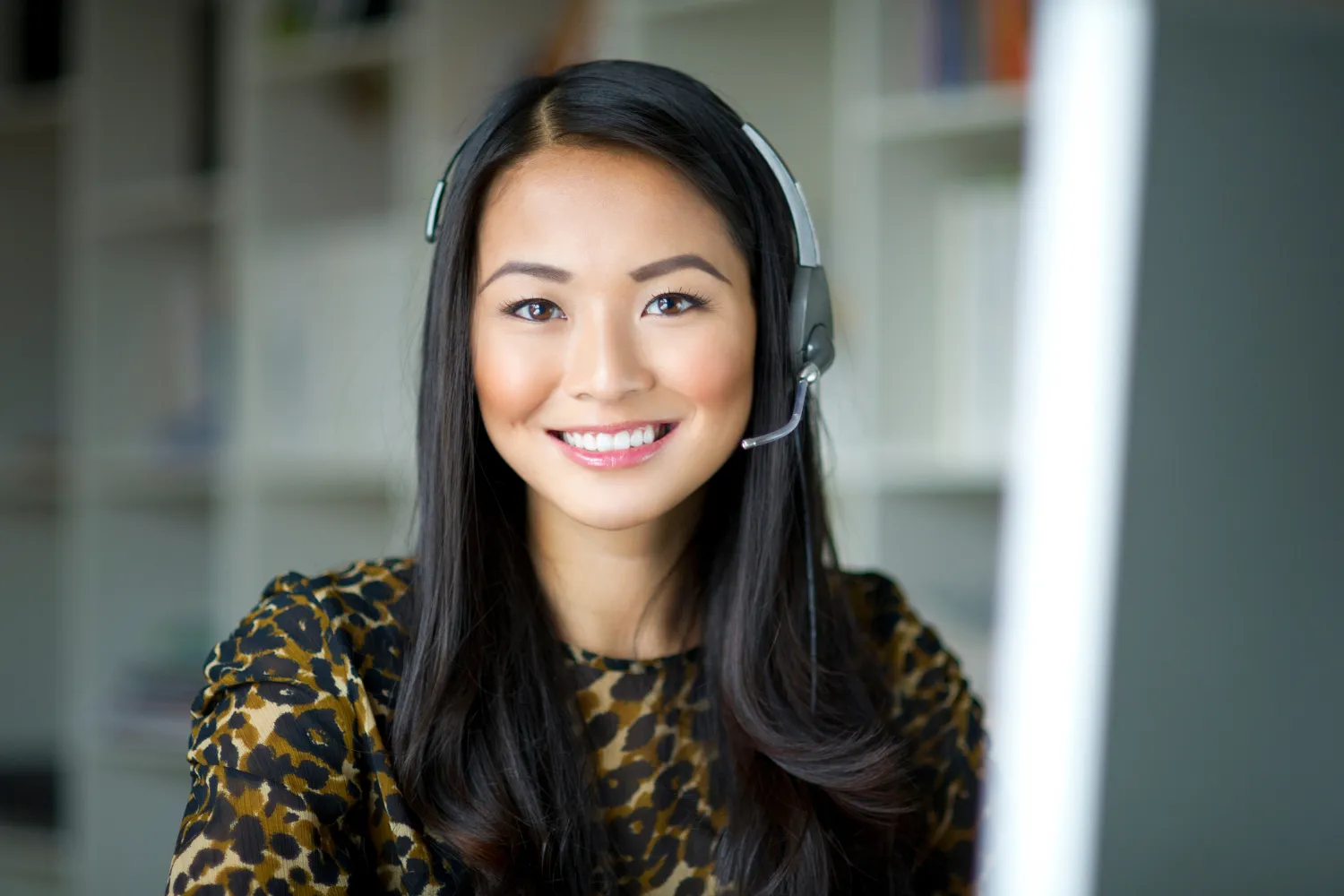 Remote employee with headset smiling at camera.