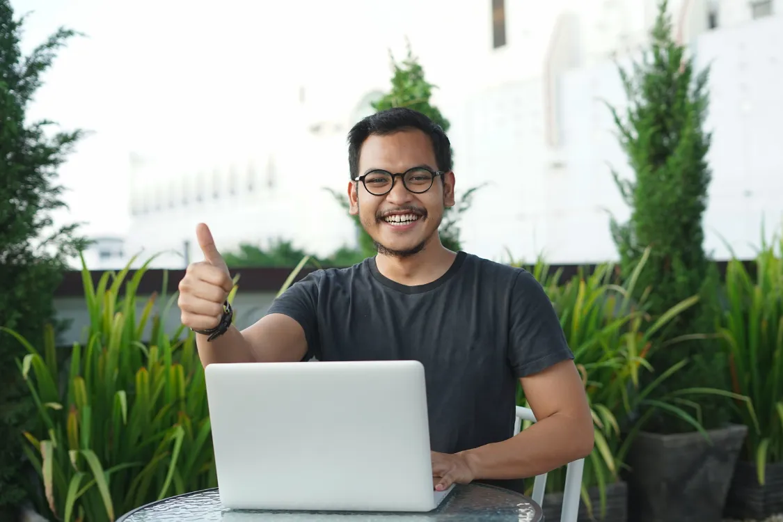 Filipino man outdoors giving thumbs up during a remote job interview