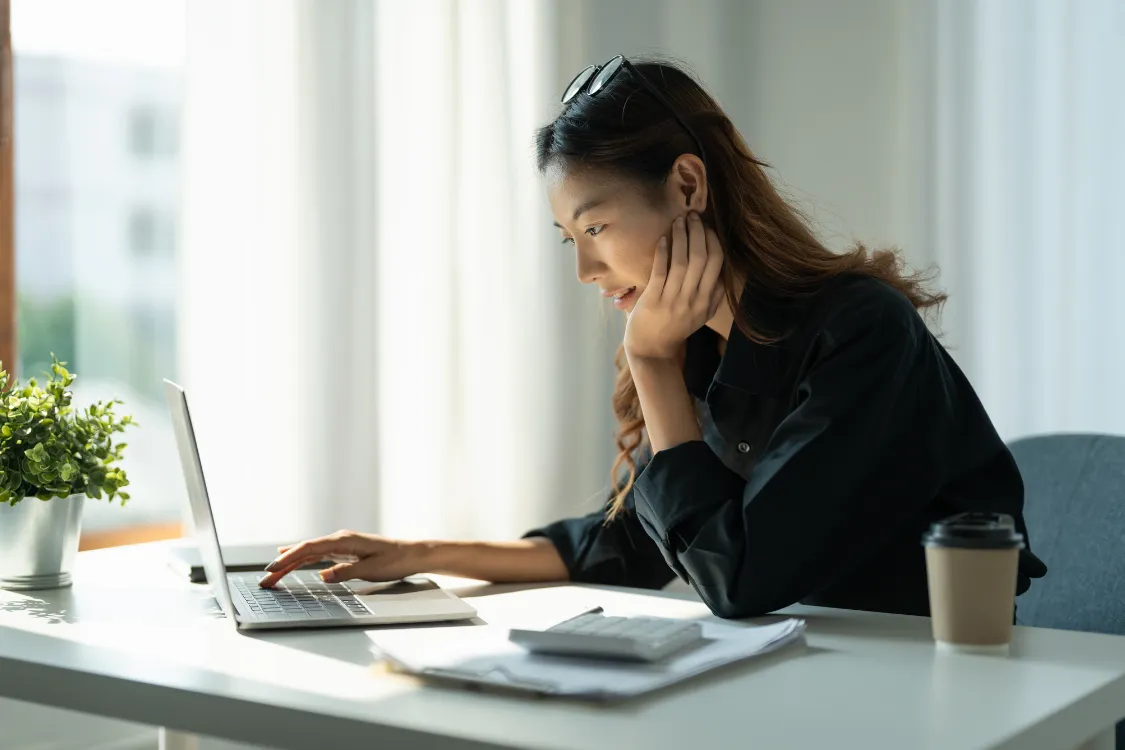 Filipina remote worker focused on completing a skills assessment test on her laptop at home