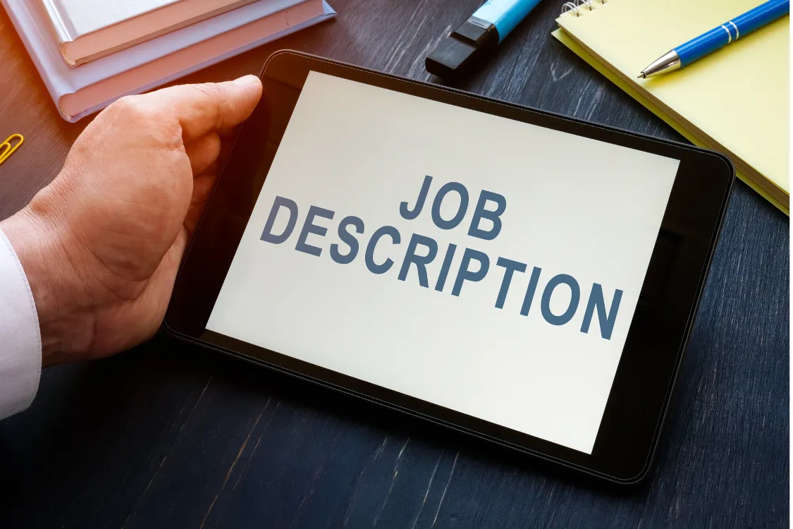 Tablet screen displaying the words job description as part of hiring process for virtual assistant roles
