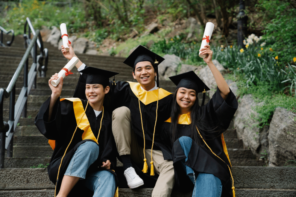 Three Filipino college graduates in caps and gowns celebrating, highlighting the talent pool available for recruitment.