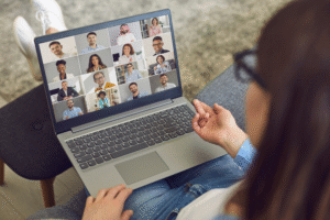 A Filipino remote worker talking to other coworkers through video conference.