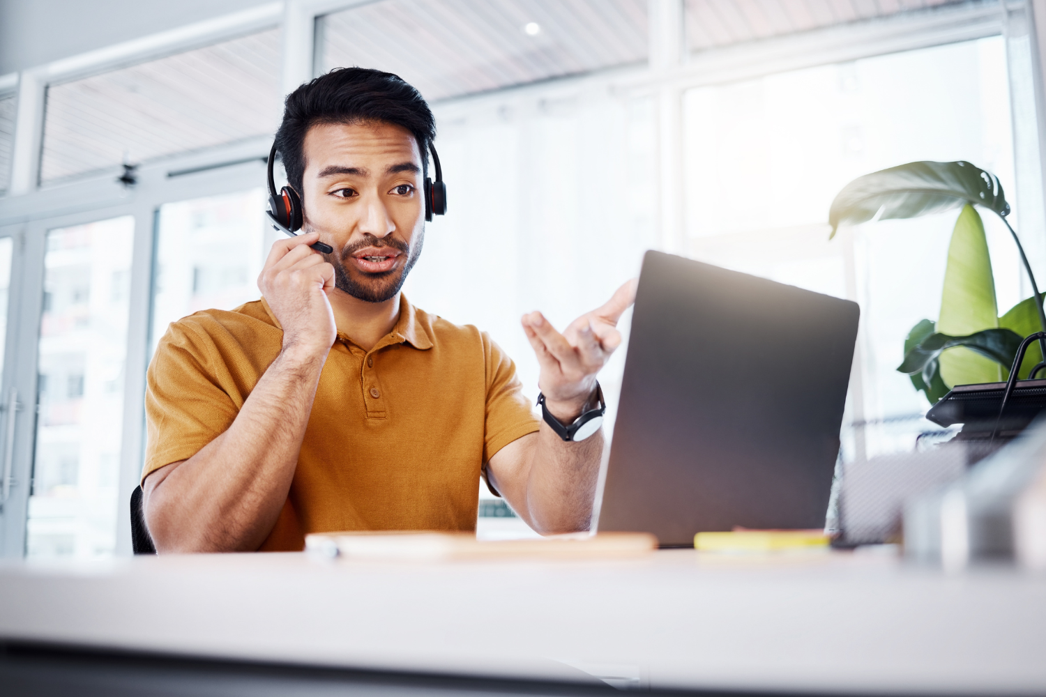 Filipino remote employee on video call wearing a head set.