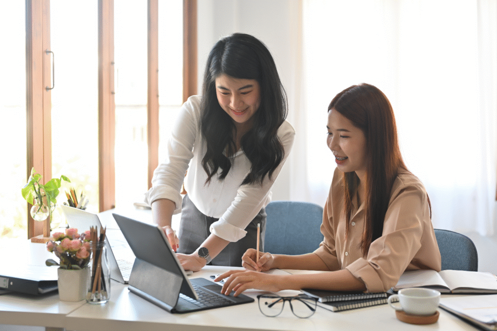 Two coworkers working together in an office setting.