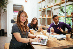 Smiling employee with colleagues in the background.