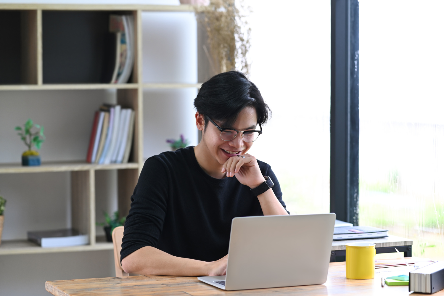 Remote employee smiling while working on his laptop.