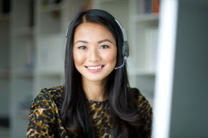 Remote employee with headset smiling at camera.