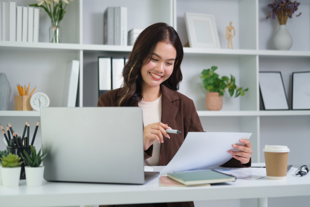 Woman on laptop while reviewing documents.